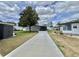 Well-maintained exterior featuring manicured lawn, mature trees, and a covered parking space at 102 Dogwood Trl, Leesburg, FL 34748