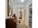 Hallway featuring an open door to the bathroom with a decorative shower curtain and a bedroom in the distance at 102 Dogwood Trl, Leesburg, FL 34748