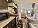 Well-equipped kitchen featuring dark cabinetry, stainless appliances, and view into the living area at 102 Dogwood Trl, Leesburg, FL 34748