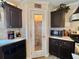 Kitchen showing dark cabinetry, stainless steel appliances, tile backsplash, and a glass-paneled pantry door at 102 Dogwood Trl, Leesburg, FL 34748