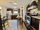Well-lit kitchen featuring dark cabinetry, stainless steel appliances, and a mobile kitchen island at 102 Dogwood Trl, Leesburg, FL 34748