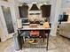 Bright kitchen showcases dark cabinets, stainless appliances, tiled backsplash, and mobile kitchen island at 102 Dogwood Trl, Leesburg, FL 34748
