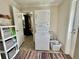Convenient laundry room with stacked washer and dryer, shelving, and a colorful rug at 102 Dogwood Trl, Leesburg, FL 34748