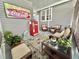 Relaxing porch area with comfortable wicker furniture, fun coca cola theming, and plants at 102 Dogwood Trl, Leesburg, FL 34748