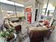 Cozy screened-in porch featuring comfortable wicker furniture and a vintage Coca-Cola machine at 102 Dogwood Trl, Leesburg, FL 34748
