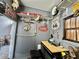 Organized storage room with a black tool chest, vintage signage, and access to a porch at 102 Dogwood Trl, Leesburg, FL 34748