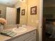 Bathroom vanity with mirror, natural light, neutral paint and door to ensuite bedroom at 1070 Pinewood Pl, The Villages, FL 32162