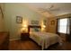 Bedroom with ceiling fan, natural light, wood laminate flooring and ensuite bathroom at 1070 Pinewood Pl, The Villages, FL 32162