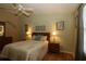 Bedroom with ceiling fan, natural light, wood laminate flooring, and ensuite bathroom at 1070 Pinewood Pl, The Villages, FL 32162