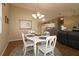 Open dining area with chandelier, wooden floors, and views of the living room and kitchen at 1070 Pinewood Pl, The Villages, FL 32162