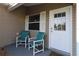 Covered front porch with seating and a white front door at 1070 Pinewood Pl, The Villages, FL 32162