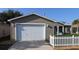 Home with a two-car garage and a white picket fence at 1070 Pinewood Pl, The Villages, FL 32162