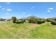 Manicured backyard features lush green lawn, landscaping and screened-in lanai, perfect for outdoor living at 1182 Allaire Loop, The Villages, FL 32163