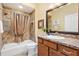 Bathroom with a combination shower and tub, granite vanity, tile surround, and framed mirror at 1182 Allaire Loop, The Villages, FL 32163