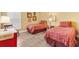 Cozy bedroom with two twin beds and laminate floors with a neutral color scheme, and a rocking chair at 1182 Allaire Loop, The Villages, FL 32163