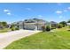 Side exterior of the home with mature landscaping and a spacious driveway at 1182 Allaire Loop, The Villages, FL 32163