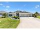 Charming single-story home featuring a well-manicured lawn and a three-car garage at 1182 Allaire Loop, The Villages, FL 32163