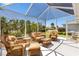 Enclosed patio features neutral flooring and plenty of natural sunlight illuminating the comfortable wicker furniture at 1182 Allaire Loop, The Villages, FL 32163