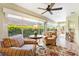 Inviting sunroom with large windows offering views of the manicured backyard, and comfortable seating at 1182 Allaire Loop, The Villages, FL 32163