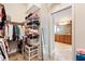 Spacious walk-in closet featuring ample shelving and hanging space, plus an adjacent bathroom with a granite-topped vanity at 1182 Allaire Loop, The Villages, FL 32163