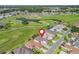 Aerial view of a home on a golf course with lush greenery and tranquil ponds at 11820 Se 178Th St, Summerfield, FL 34491