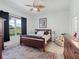 Comfortable bedroom with large window, ceiling fan and neutral decor at 11820 Se 178Th St, Summerfield, FL 34491