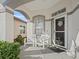 Charming covered porch with comfortable seating, framed by an arched entryway at 11820 Se 178Th St, Summerfield, FL 34491