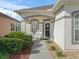 Inviting front porch with seating and a decorative door, framed by lush landscaping at 11820 Se 178Th St, Summerfield, FL 34491