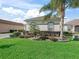Beautifully landscaped front yard with vibrant green grass and manicured shrubs at 11820 Se 178Th St, Summerfield, FL 34491