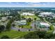 Aerial view of the community featuring a large pond, ball field, clubhouse, and ample green spaces at 11884 Se 179Th St, Summerfield, FL 34491