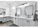 Bright bathroom featuring double sinks, vanity area with stool and stylish fixtures at 11884 Se 179Th St, Summerfield, FL 34491