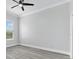 A bedroom with minimalist style, featuring light gray laminate flooring, a window, and ceiling fan at 11884 Se 179Th St, Summerfield, FL 34491