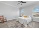 Bright bedroom with a ceiling fan, neutral walls, wood-look floors, and a rocking chair creating a cozy space at 11884 Se 179Th St, Summerfield, FL 34491