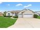 Inviting home with a three-car garage, lush lawn, and freshly manicured landscaping in daylight at 11884 Se 179Th St, Summerfield, FL 34491