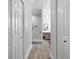 Hallway view showcasing doors and leading to bathroom with glass enclosed shower and makeup vanity at 11884 Se 179Th St, Summerfield, FL 34491