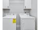 Bright laundry room featuring a washer and dryer with energy guide and white cabinets above at 11884 Se 179Th St, Summerfield, FL 34491