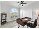 Bright office space with a large arched window, ceiling fan and a modern wood desk and decorative shelving at 11884 Se 179Th St, Summerfield, FL 34491