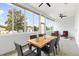 Enclosed patio featuring sleek tile flooring, lots of windows and a wooden dining set for outdoor living and entertaining at 11884 Se 179Th St, Summerfield, FL 34491