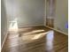 Sunlit bedroom featuring light colored walls, wood floors, and a window with wooden blinds at 1231 Merion Dr, Mount Dora, FL 32757