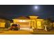 Charming exterior of a home at night with a well-manicured lawn and landscaping under a full moon at 1231 Merion Dr, Mount Dora, FL 32757