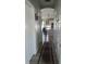 Hallway leading to kitchen with decorative rug and multiple doors at 1231 Merion Dr, Mount Dora, FL 32757