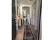 Inviting hallway with wood-look tile and decorative rug leading into the open-concept living space at 1231 Merion Dr, Mount Dora, FL 32757