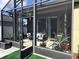 Screened patio with sitting area and exterior view of fence and shrubbery at 1231 Merion Dr, Mount Dora, FL 32757