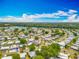 Community shot with a lake in the distance, featuring neat streets lined with manicured lawns and homes at 1236 Elkhart Cir, Tavares, FL 32778