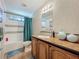 Bathroom featuring a shower-tub combo, wooden vanity, and a framed mirror at 1236 Elkhart Cir, Tavares, FL 32778