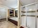 Bathroom showcasing a shower, bathtub with dark wood trim, and built-in shelves at 1236 Elkhart Cir, Tavares, FL 32778
