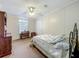 Cozy bedroom with a ceiling fan, dark wood furniture, and natural light from the window at 1236 Elkhart Cir, Tavares, FL 32778