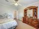 Cozy bedroom featuring decorative bed linens, ceiling fan, and a dark wood dresser with mirror at 1236 Elkhart Cir, Tavares, FL 32778