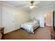 This bedroom offers neutral paint, trim, a ceiling fan, and a doorway leading to an ensuite bathroom at 1236 Elkhart Cir, Tavares, FL 32778