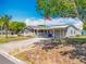 Exterior view of a well-kept single-story home with a spacious carport and flag pole at 1236 Elkhart Cir, Tavares, FL 32778